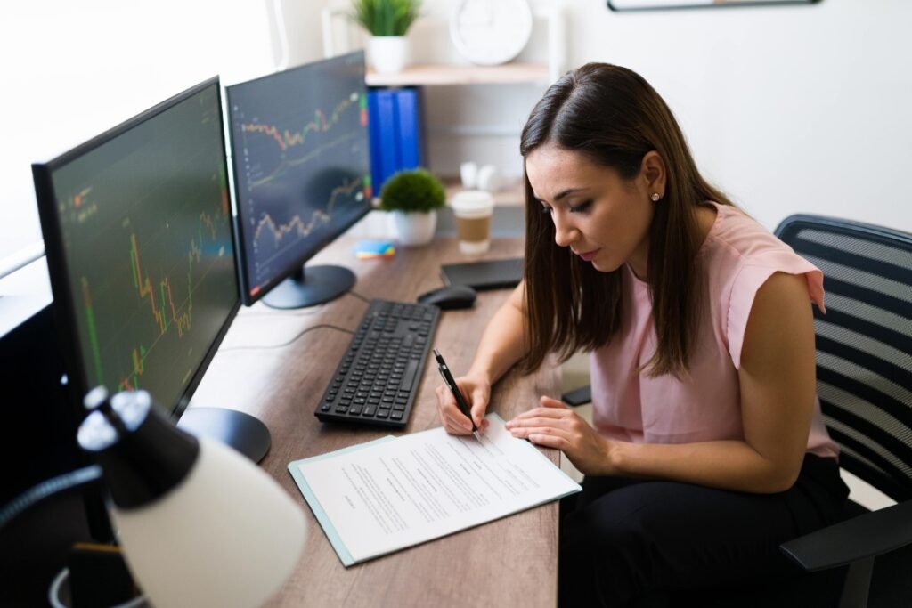 beautiful-freelancer-stock-broker-signing-business-deal-her-work-desk-successful-businesswoman-reading-work-contract-min (1) Beginner reading technical analysis books on trading desk